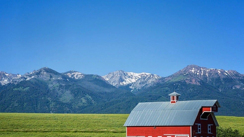 A red barn beneath Oregon's mountain ranges