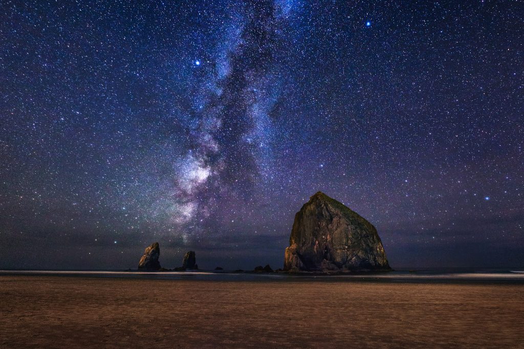 Cannon Beach Oregon under the night sky with the Milky Way showing.