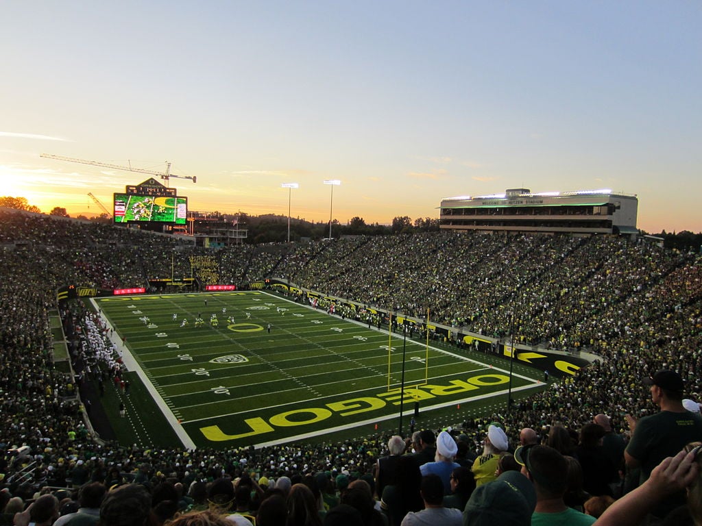 A packed Autzen Stadium during an Oregon Ducks football game at sunset
