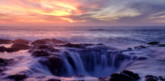 Thor's Well at sunset. It looks like there's a massive hole in the ocean draining all the water.