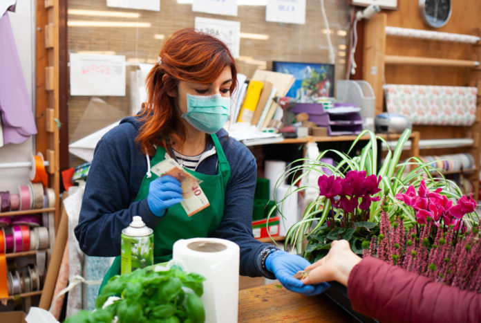 florist-receives-a-payment-from-a-customer-wearing-337WPKQ