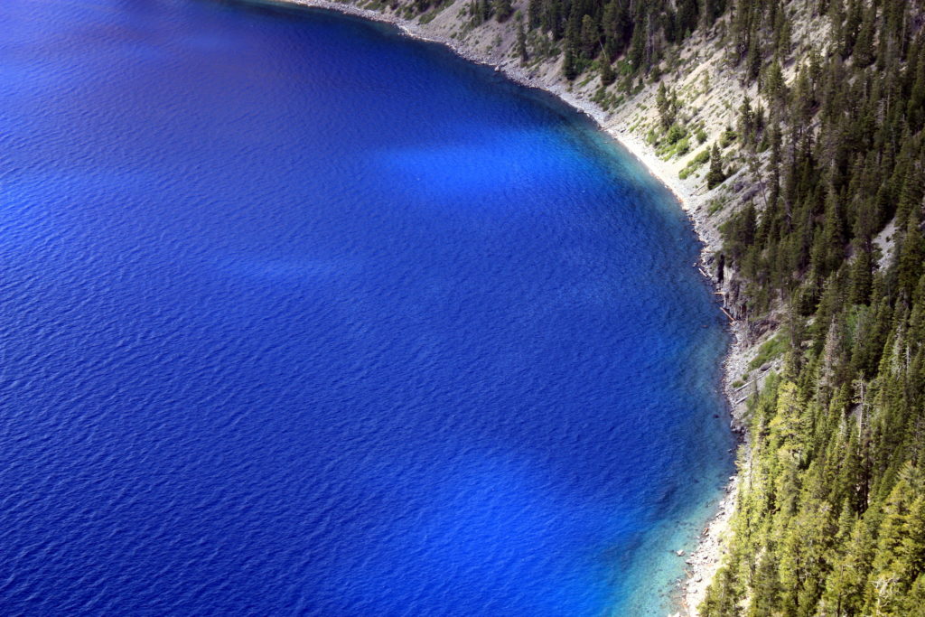 Crater lake's crystal clear waters as seen from above.