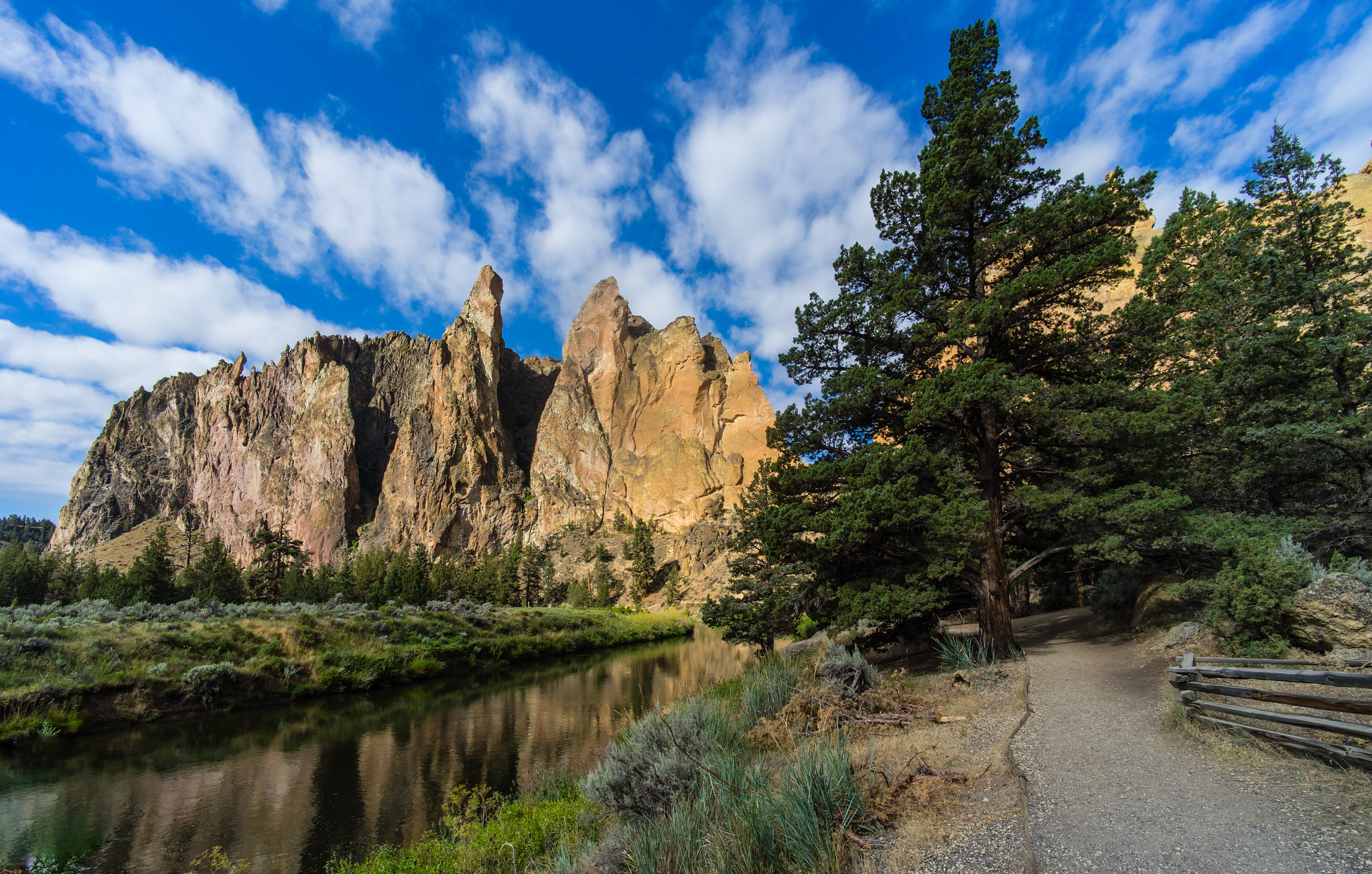 Smith Rock State Park on a sunny day with Deschutes River in the foreground
