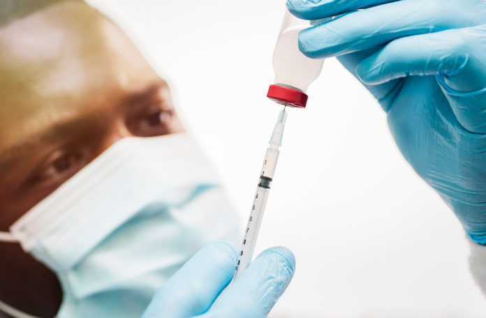 A man drawing a vaccine with a needle for Covid 19