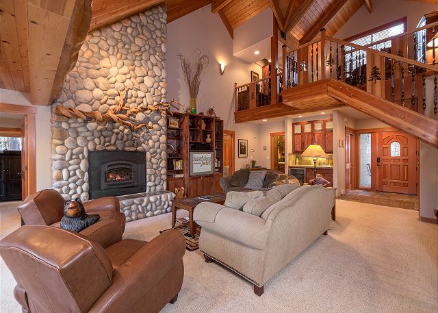 A gorgeous cabin interior in Sunriver with a big stone fireplace and gorgeous wood details.