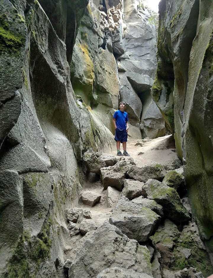 A boy inside a volcanic fissure in Oregon.
