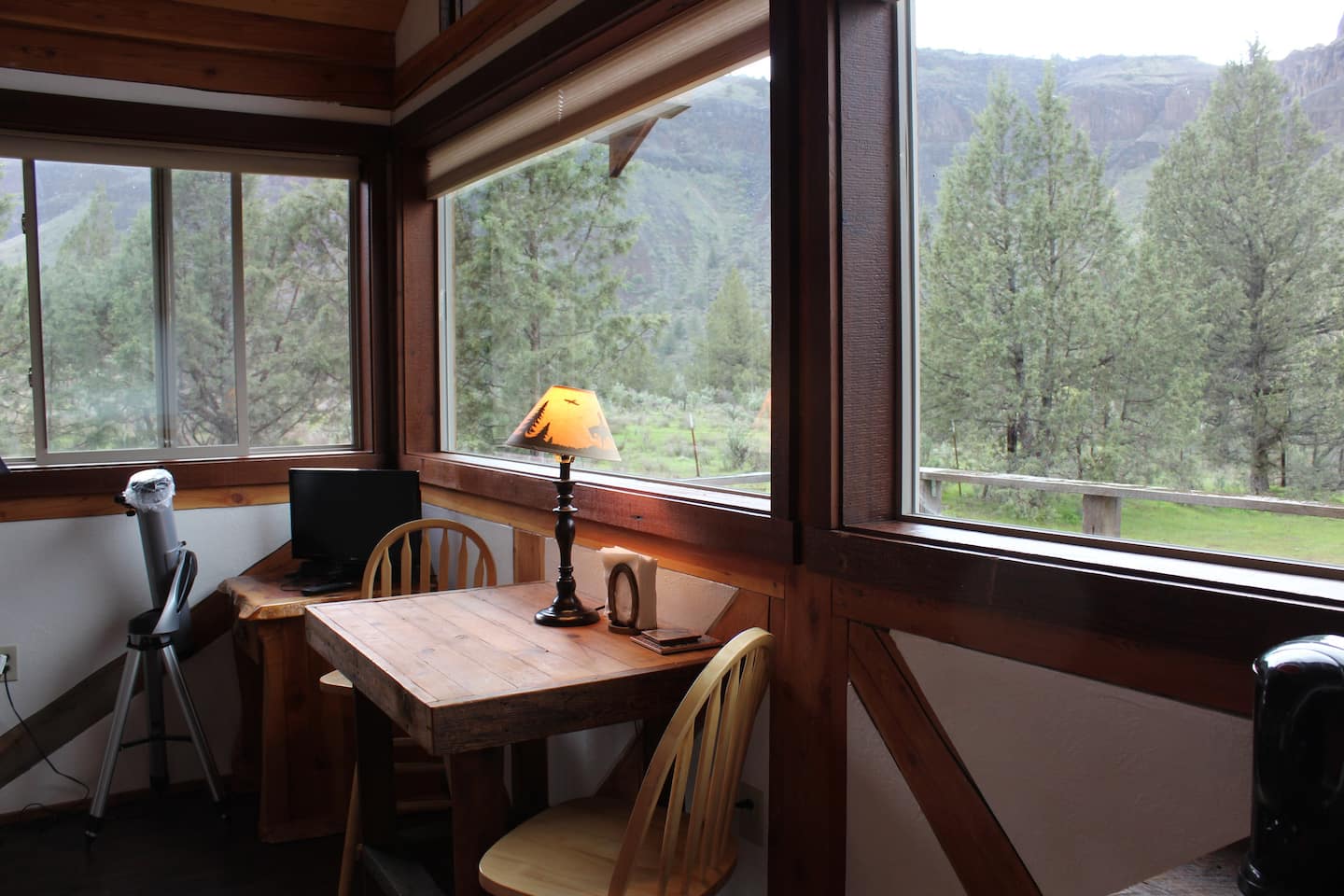 A table inside a cabin in front of a window with a view of trees