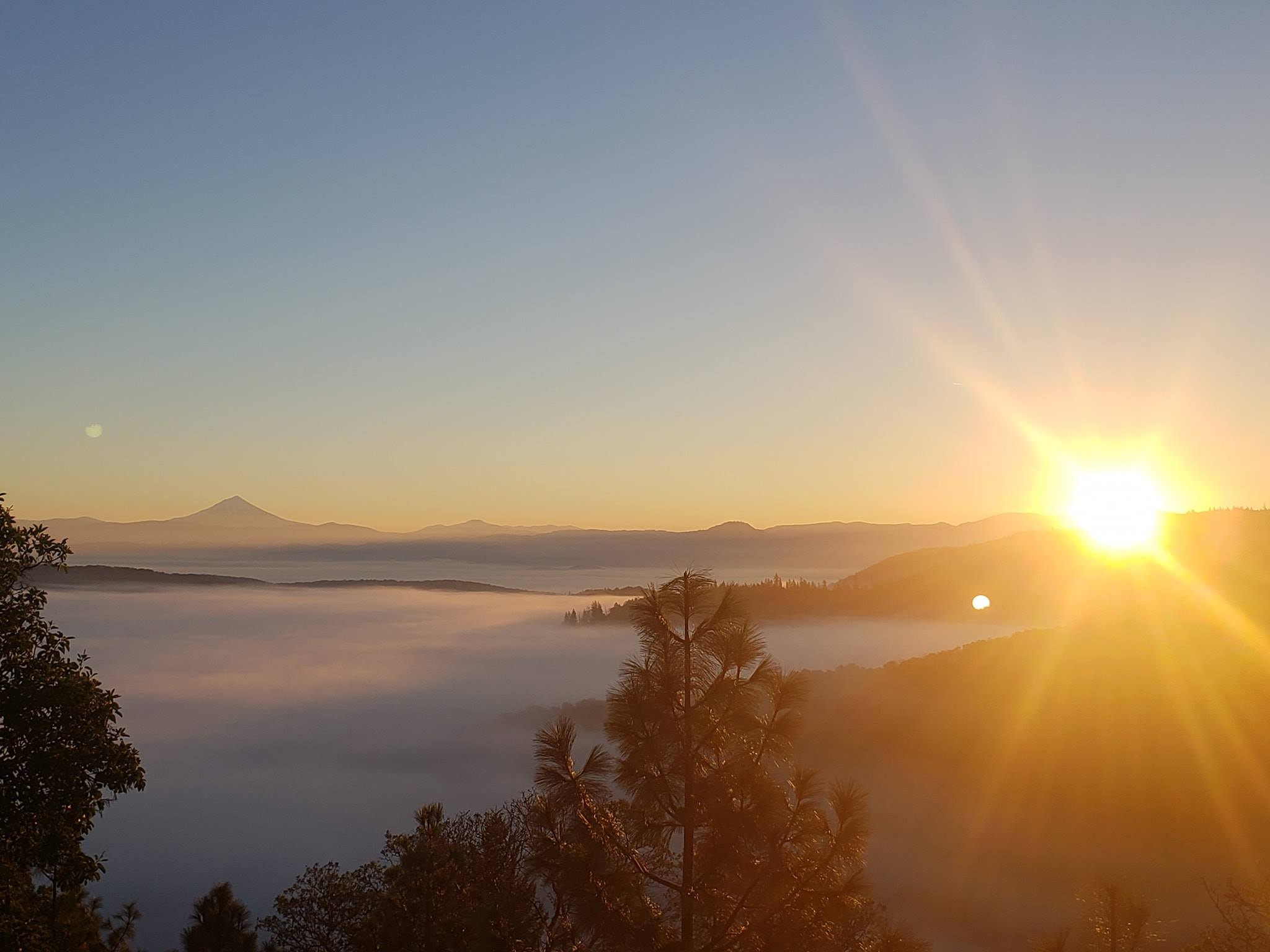 View of the sunrise over mountains and a valley of fog