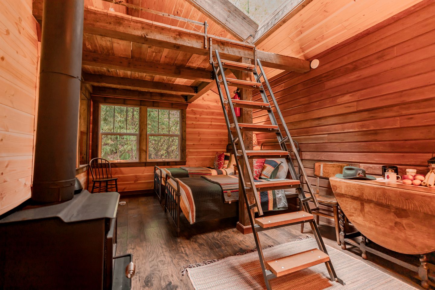 The cabin interior with two beds and a ladder to the loft bed