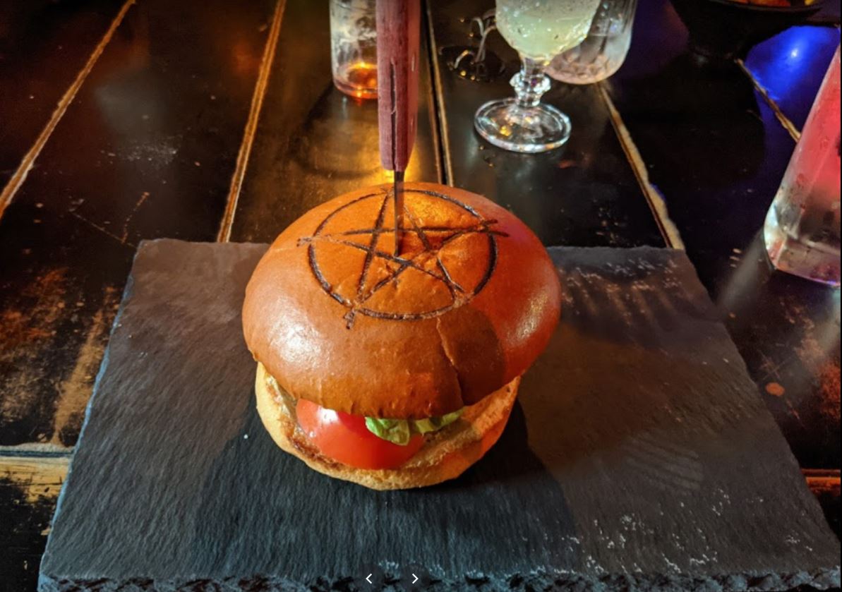 Raven's Manor a burger with a pentagram bun and knife portland oregon