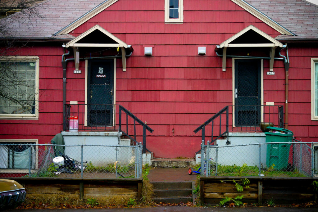Two doors in front of red duplex rental in Portland Oregon