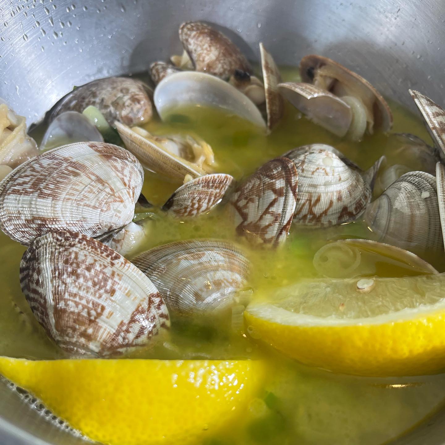 Fresh seafood in a lemon sauce with lemons. The bowl of food is bright and colorful. At Mo's in Newport, Oregon.