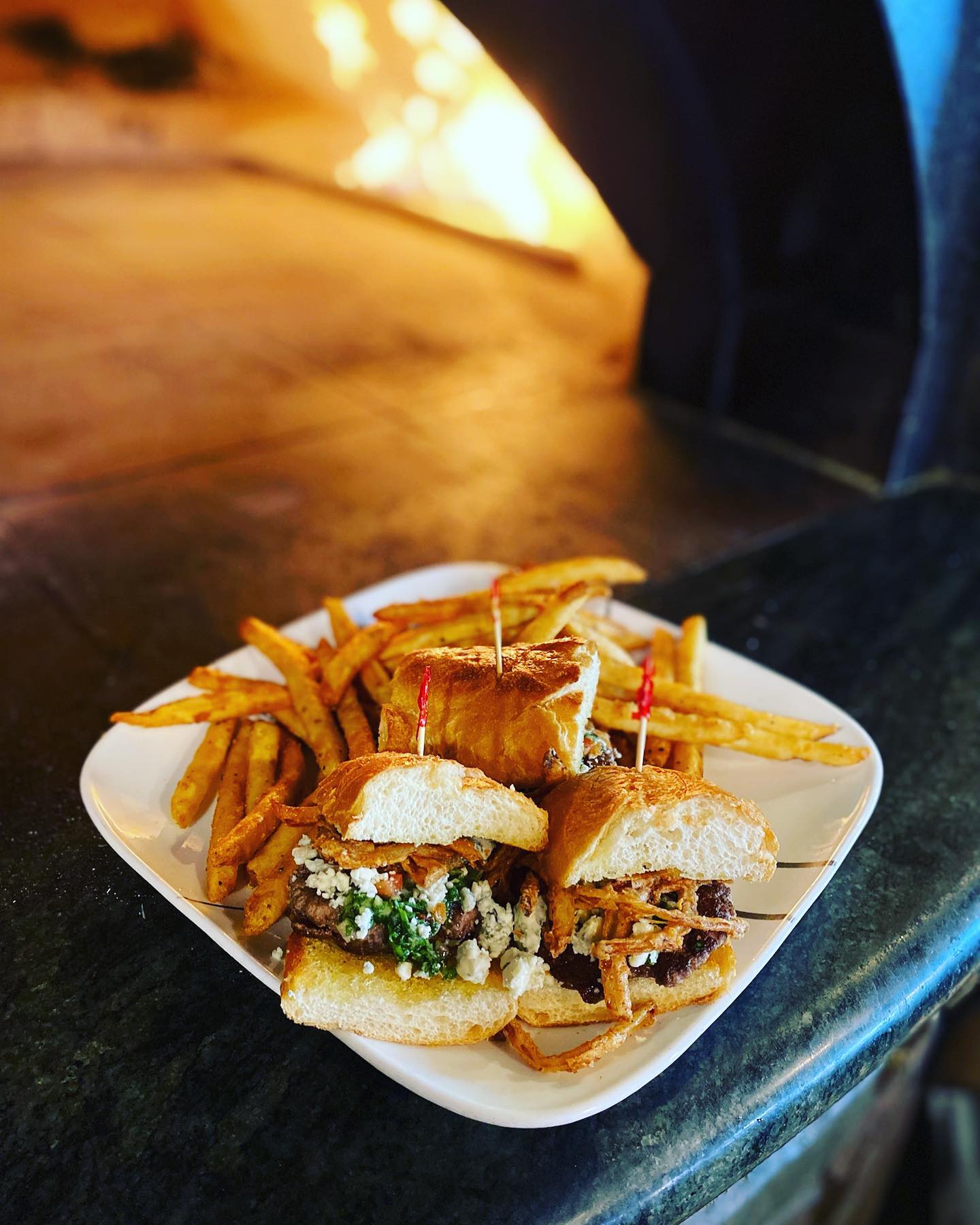 A tasty looking sandwich with fries in front of a wood fired oven at Smoky Hearth Bar And Grill in Sandy, Oregon