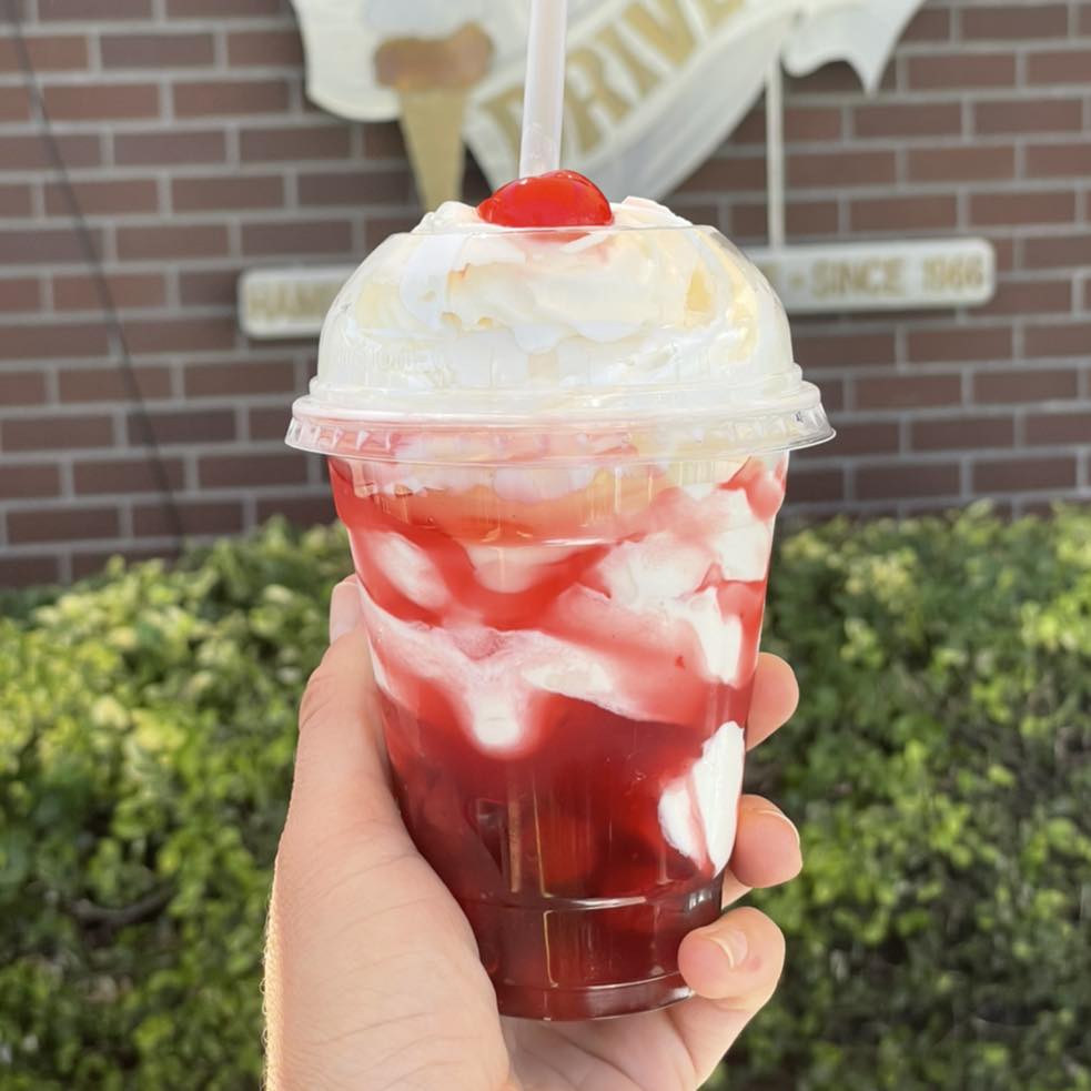 A colorful red milkshake with whip cream from Big Jim's Drive In.