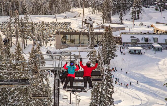 Two people sitting on a chairlift at Cooper Spur Mountain Resort at Mt. Hood
