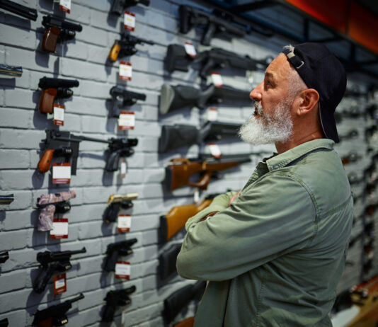 A man looking at guns at a firearm store. Oregon gun control laws 2022, 2023.