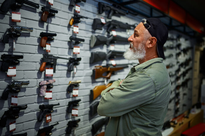 A man looking at guns at a firearm store. Oregon gun control laws 2022, 2023.