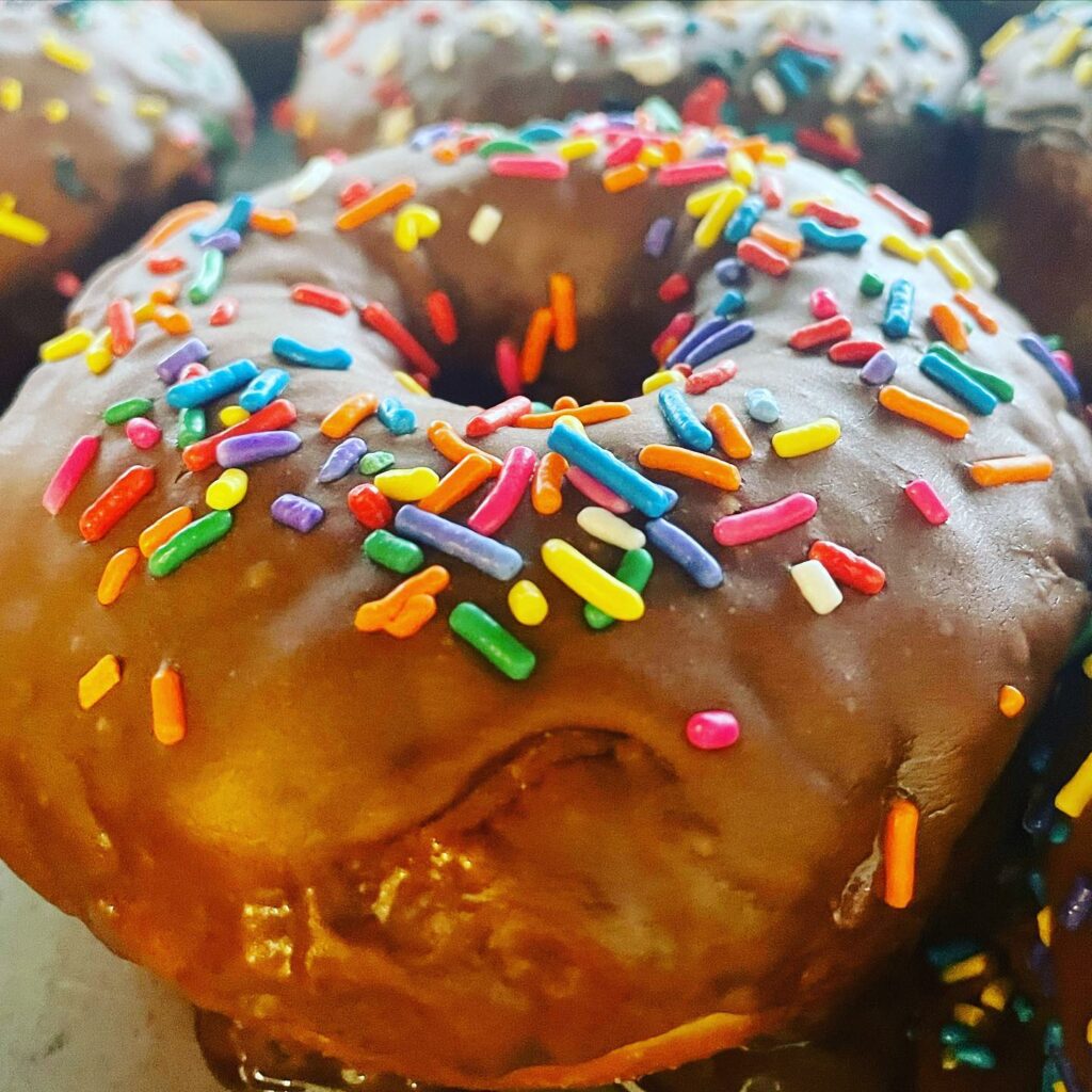 A donut with frosting and colorful sprinkles.