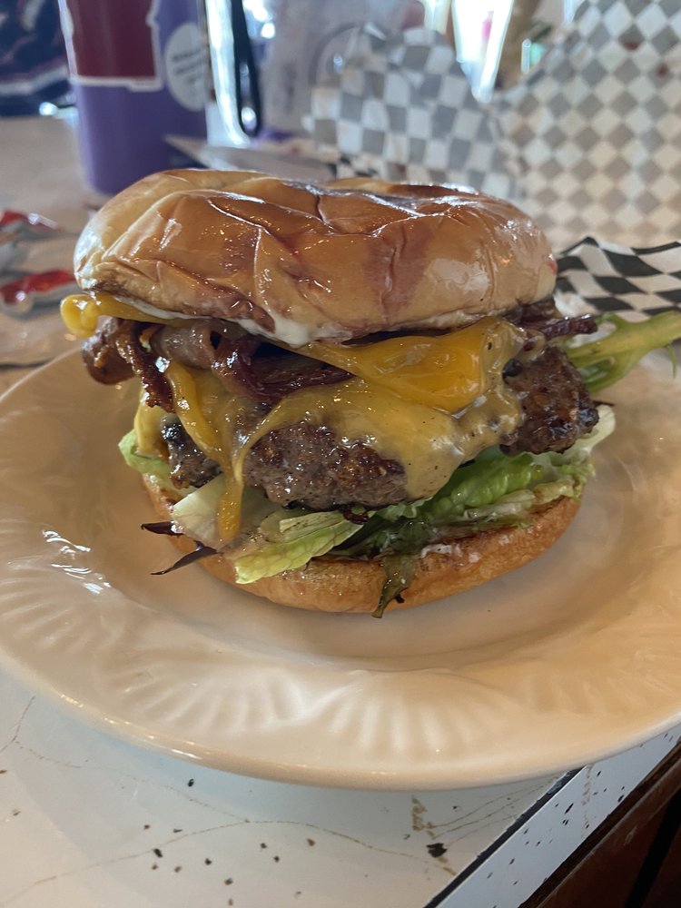 A huge bacon burger with cheese. Looks really good.