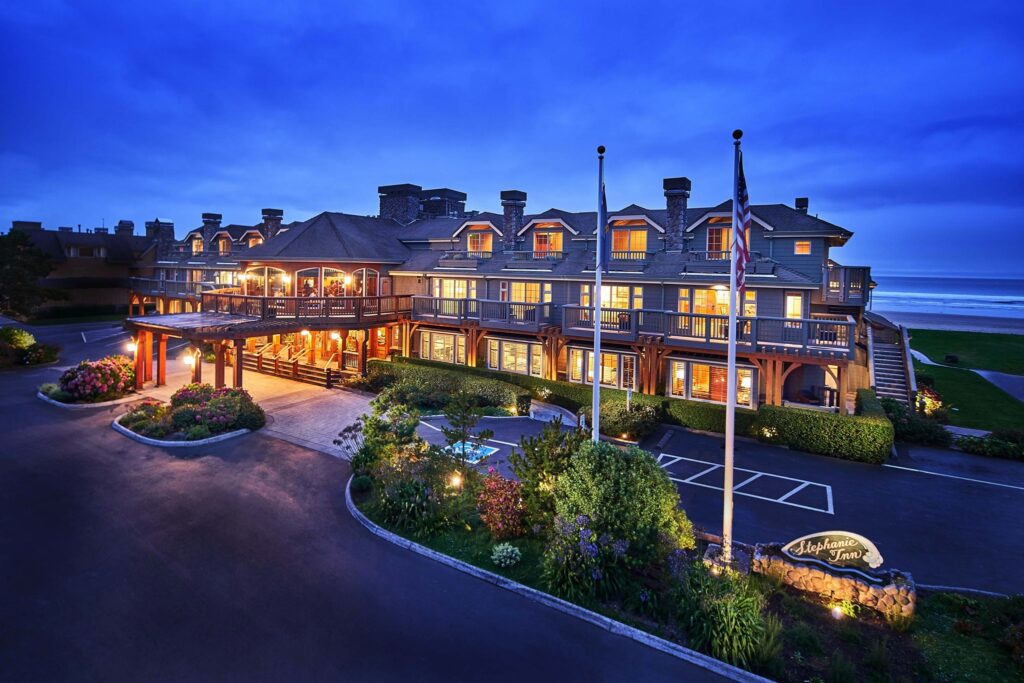 Stephanie Inn at Cannon Beach at night, with all the lights on and casting a warm glow.