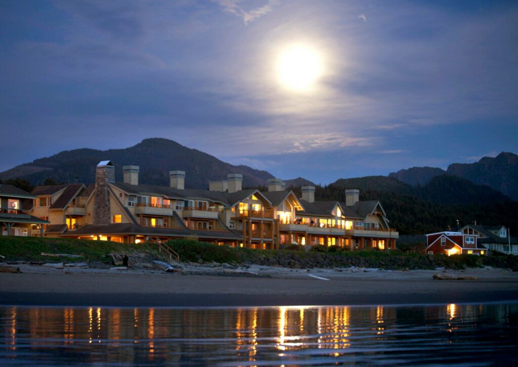 The Ocean Lodge exterior at night lit by the moon as seen from the beach.