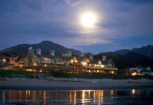 The Ocean Lodge exterior at night lit by the moon as seen from the beach.