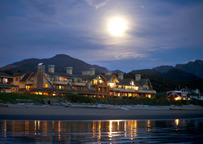 The Ocean Lodge exterior at night lit by the moon as seen from the beach.