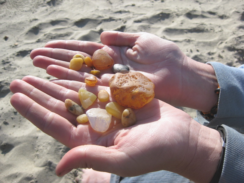 human hands holding agates on the beach in oregon