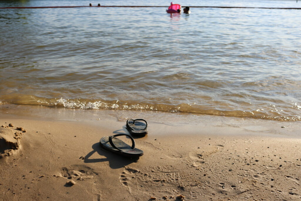 flip flops on the shore of an ocean