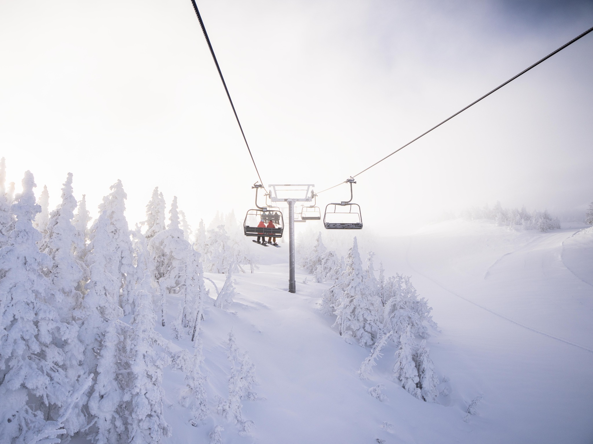 People riding the chairlift in the fog at Mount Bachelor.