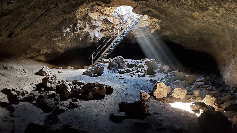 Caves In Oregon - A ladder goes down into Boyd cave with light streaming into the cave.