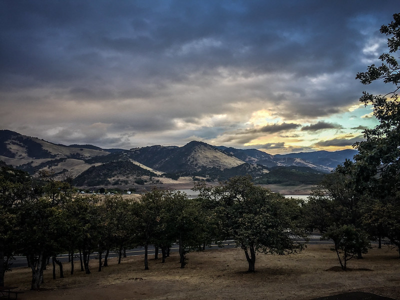 You can just see Emigrant lake through the trees off in the distance.  Brown hills rise above it in the background.