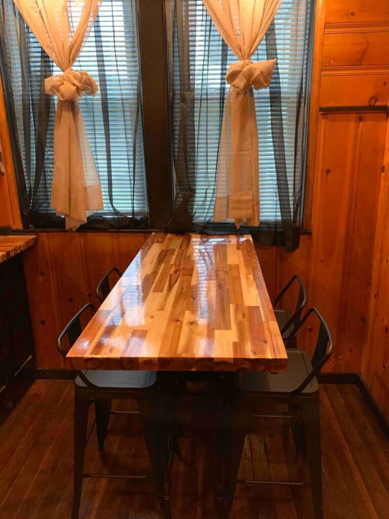 A shiny dining room table with modern black metal chairs.