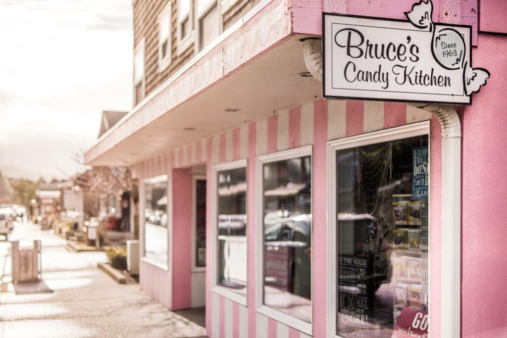 The pink and white striped exterior of Bruce's Candy Kitchen in Cannon Beach Oregon.