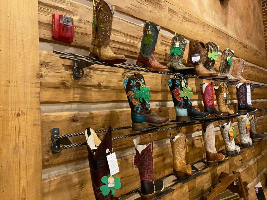 A wooden wall of colorful leather cowboy boots.