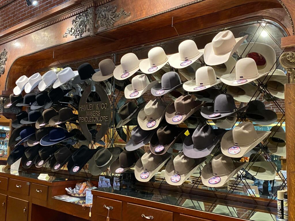 A wall of cowboy hats in a variety of shapes and colors.