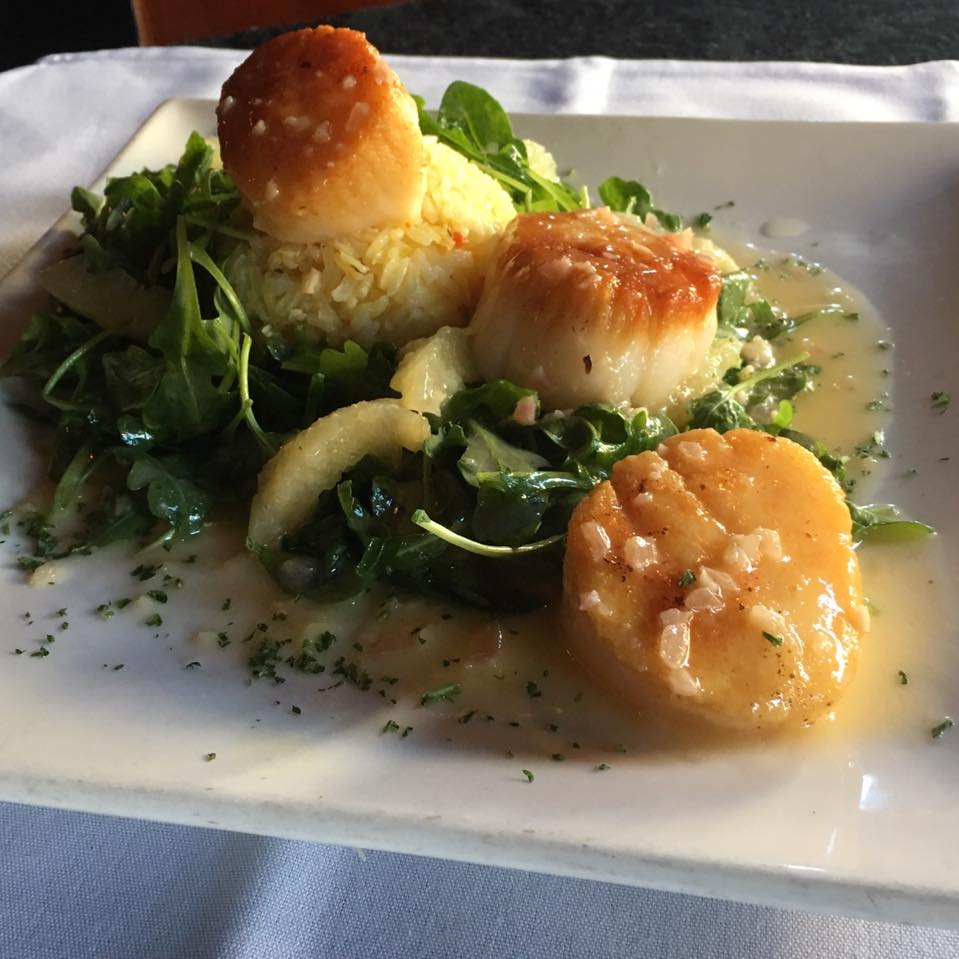 Pan seared scallops on a bed of greens with sauce at Cimmityotti's in Pendleton.