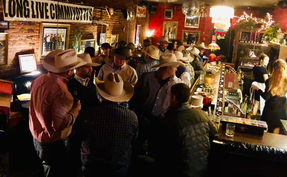 Around 30 men and women in cowboy hats crowding At Cimmityotti's on Prime Rib night.