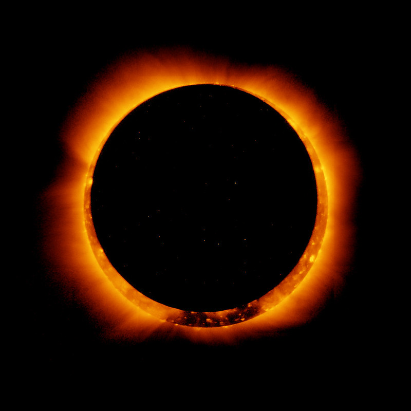 The moon covers the sun making it look like a ring of fire in the sky. Most of the photo is black aside from the ring of fire.