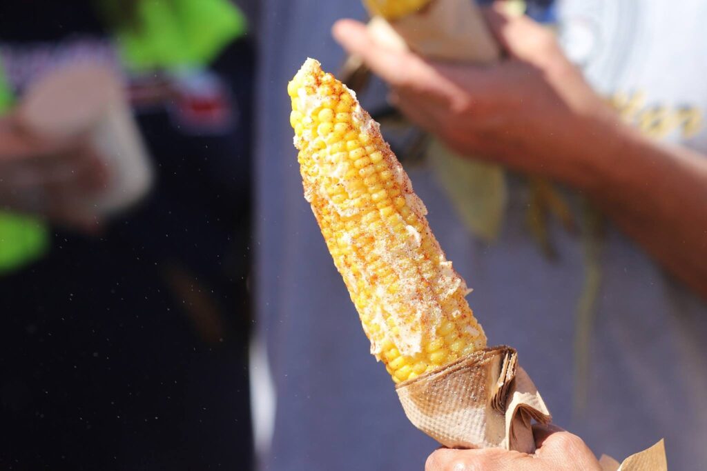 Corn on the cob sprinkled with seasoning and coated in butter.