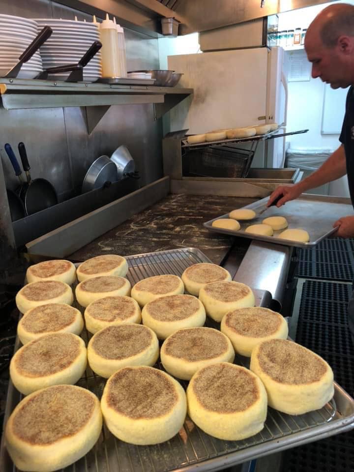 A man cooking homemade English muffins in the kitchen.