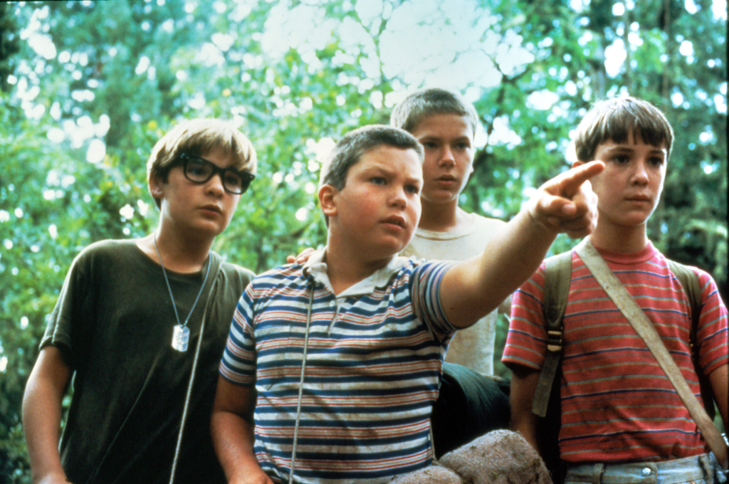 A photo of the four childhood actors in the movie Stand By Me. One is pointing at something.