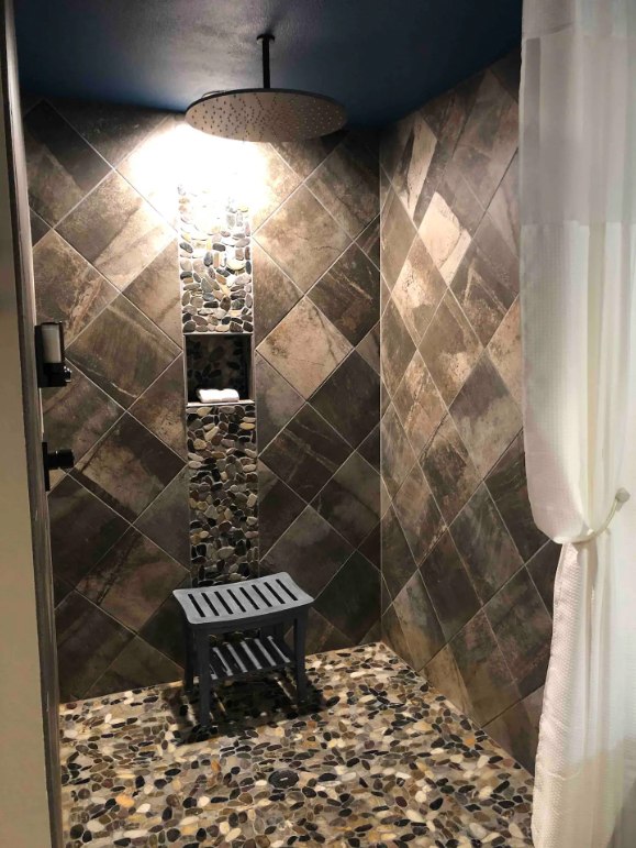 The huge walk in rain shower is tiled from floor to ceiling. It's gorgeous and looks big enough for two.
