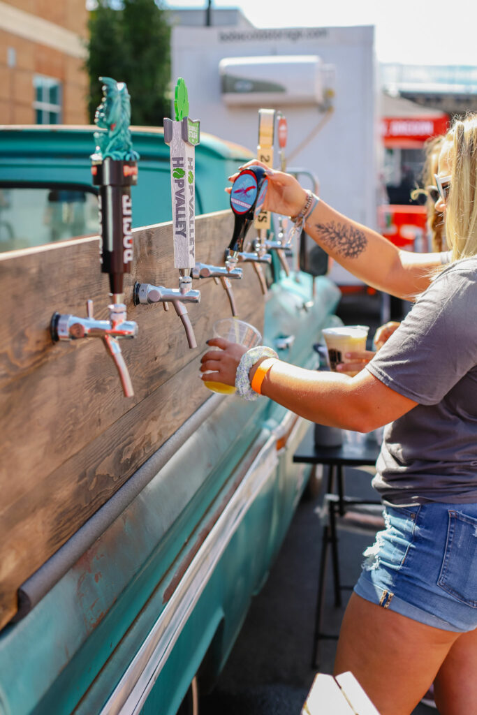 A woman pours beer from a tap.