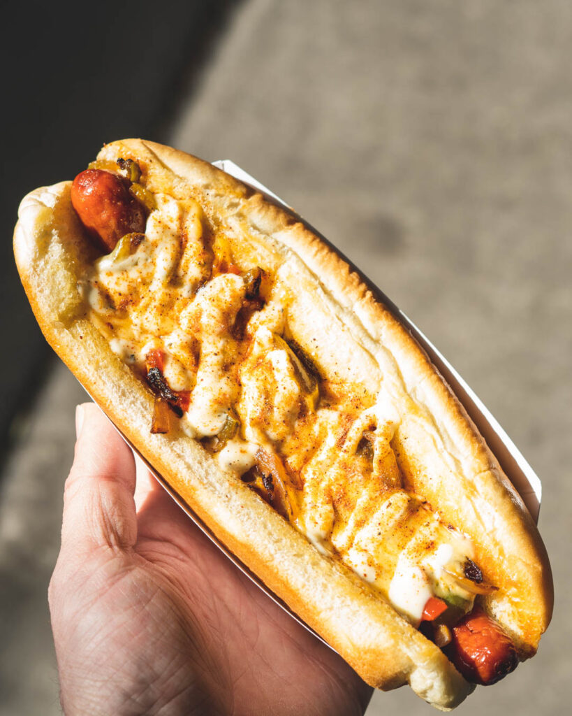 A hot dog from Bless Your Heart Burger covered in sauce.