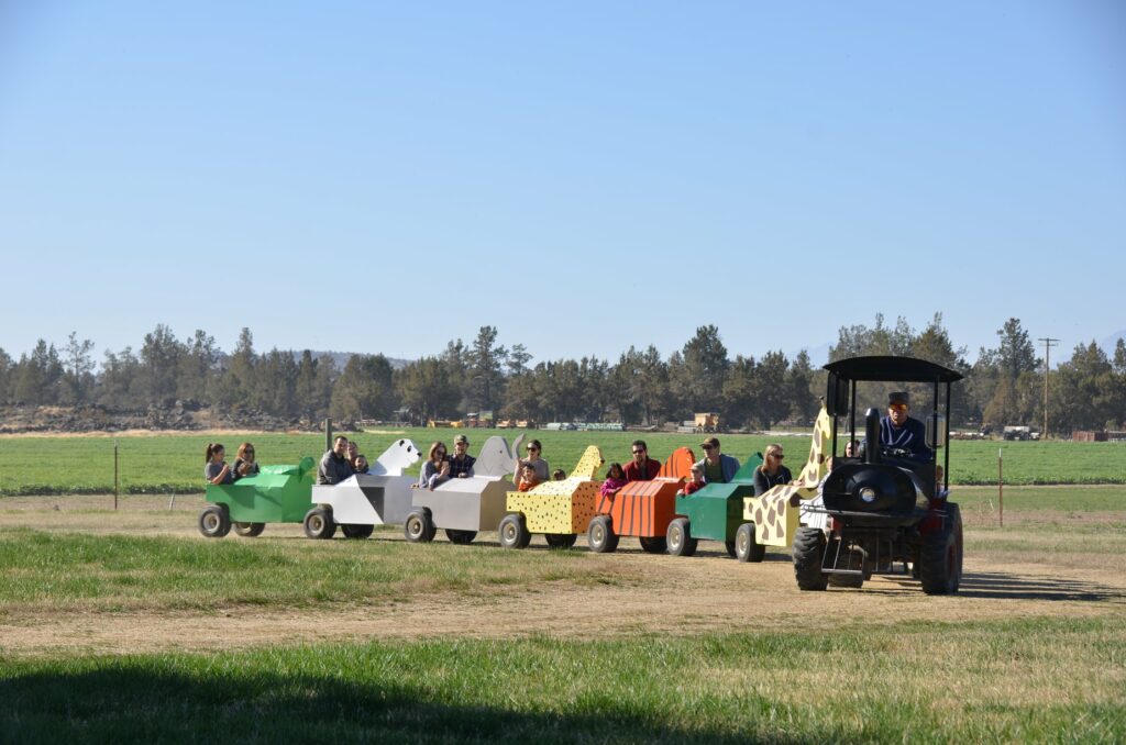 A tractor drags a train full of kids at Smith Rock Ranch.