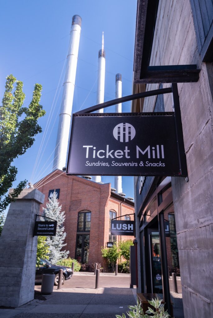 The outside of The Ticket Mill. The stacks of the old mills rise above the Ticket Mill sign.