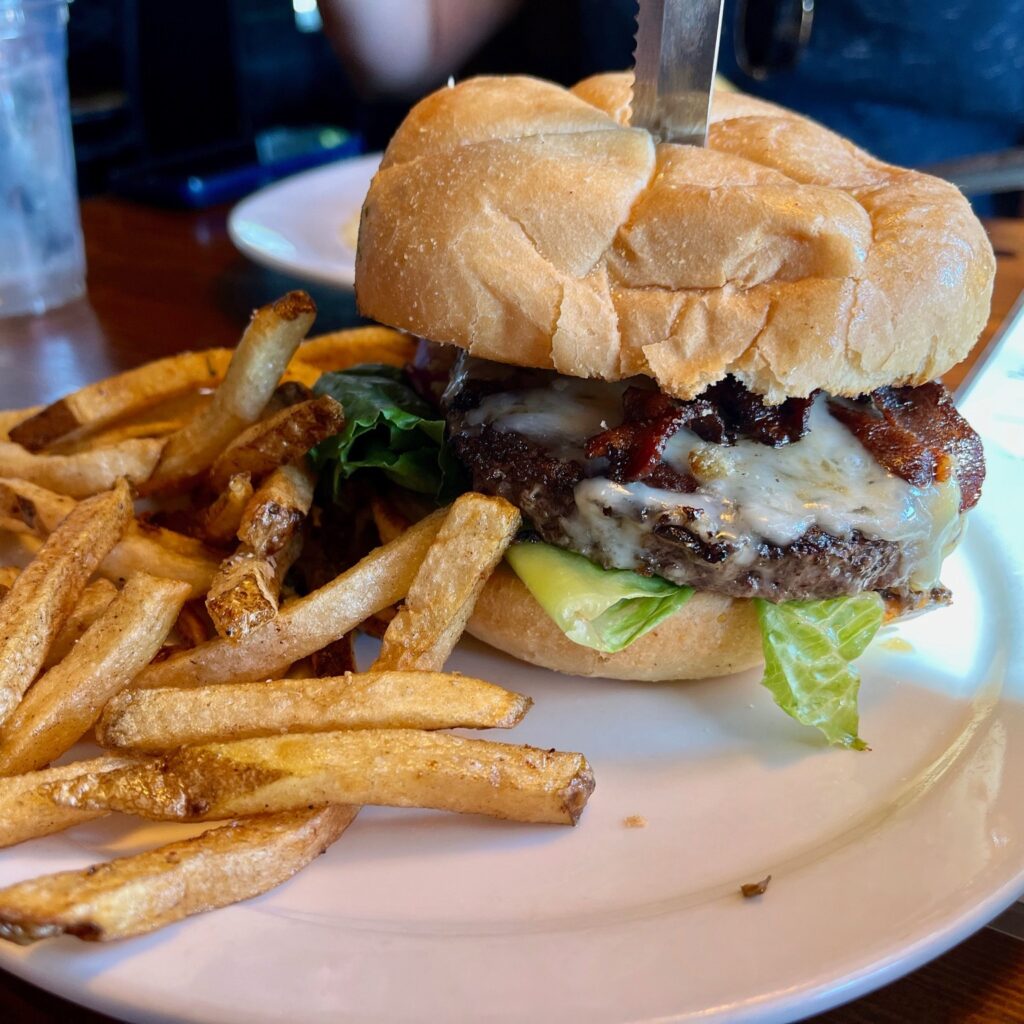 A huge burger with fries.