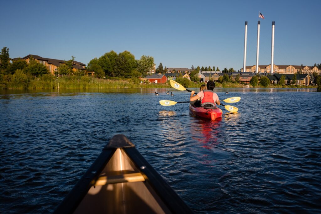 People paddle the Deschutes River in the Old Mill District.