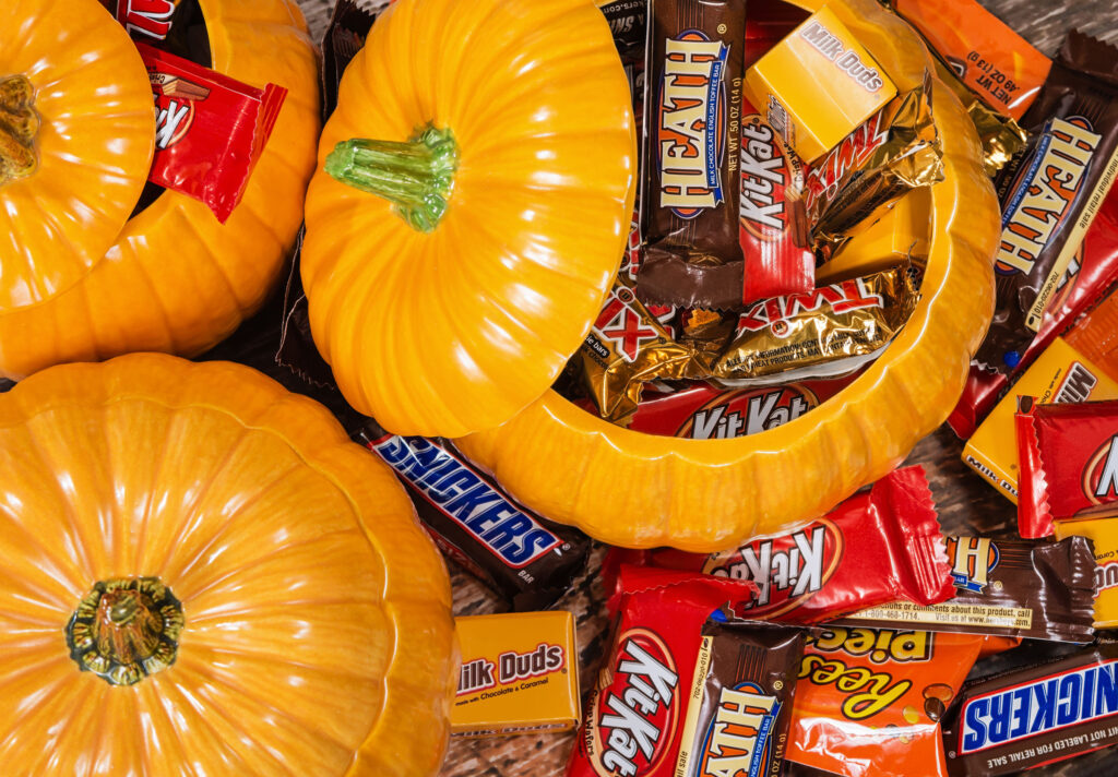 Decorative pumpkins filled with individually wrapped chocolate Halloween candy.
